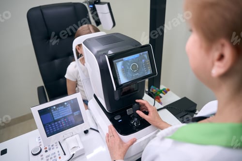 Preview: Specialist ophthalmologist examines eyes of young patient on special apparatus
