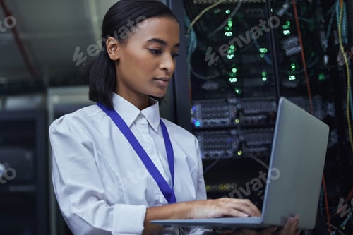 Preview: Cropped shot of an attractive female IT support agent working in a dark network server room