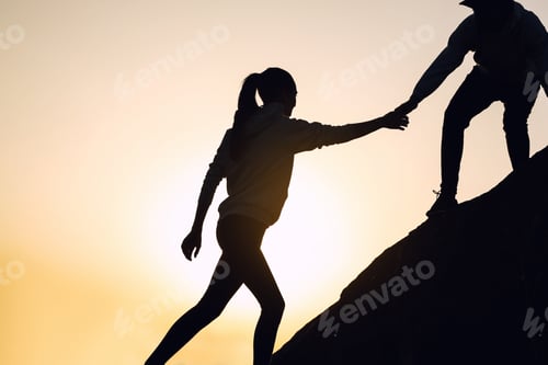 Preview: Silhouettes of man and woman helping each other to climb on hill against sunset