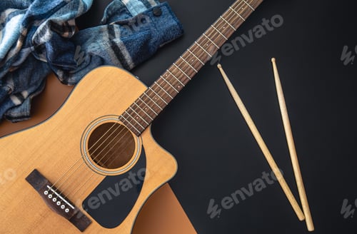Preview: Music background with guitar and drumsticks, top view.