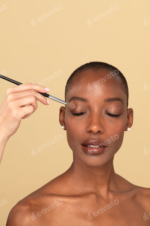 Preview: Makeup artist applying eye shadow on a black woman