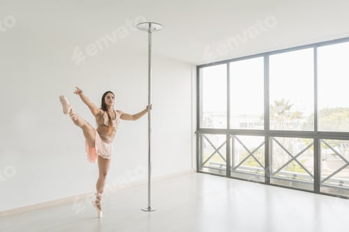 Preview: Flexible lady posing near pole in studio