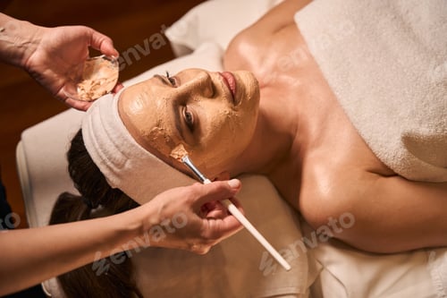 Preview: Experienced beautician performing facial rejuvenation procedure on female client