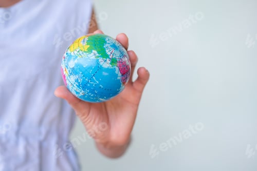 Preview: Woman holding Globe Earth on green backgrond.