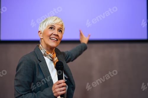 Preview: Cheerful senior woman giving a speech, presenting a new business plan.