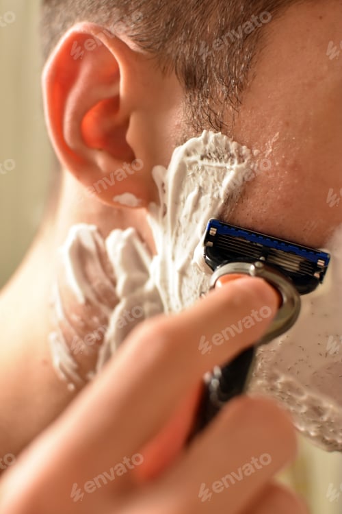Preview: Selective focus shot of a man shaving in a bathroom