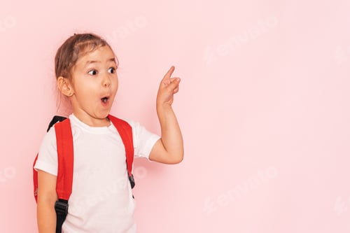 Preview: Surprised little girl with a red briefcase points her finger against a pink background