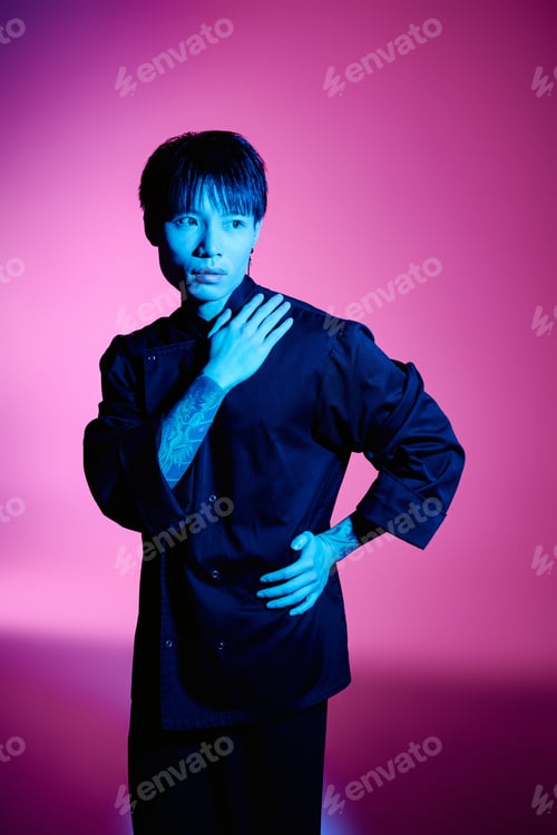 Preview: Stylish asian man posing confidently against vibrant pink background with artistic lighting