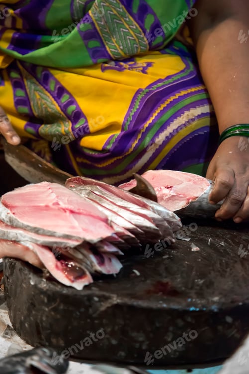 Preview: Woman cutting fish outdoor in Mumbai, India