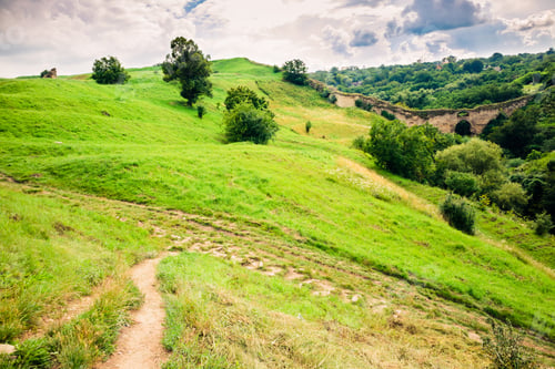 Preview: Summer view of green hills and old watchtower ruins. Green hills landscape