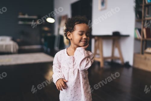 Preview: Positive sleepy black cute girl standing in spacious living room