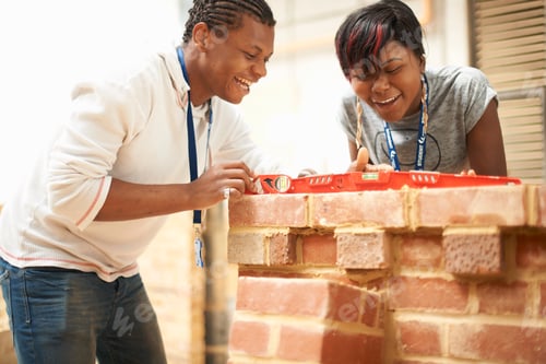 Preview: Two college students using spirit level in bricklaying workshop