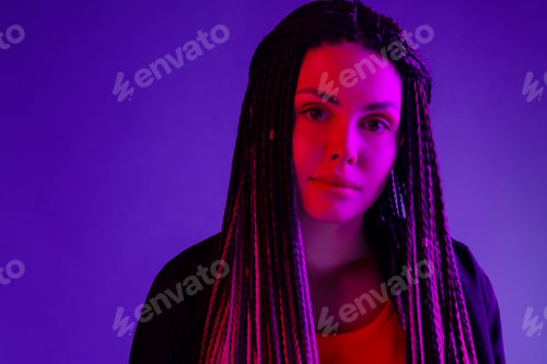 Preview: Fashion portrait of young woman with dreadlocks in neon light