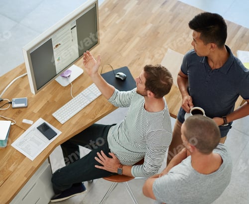 Preview: High angle shot of three designers working together on a project in an office