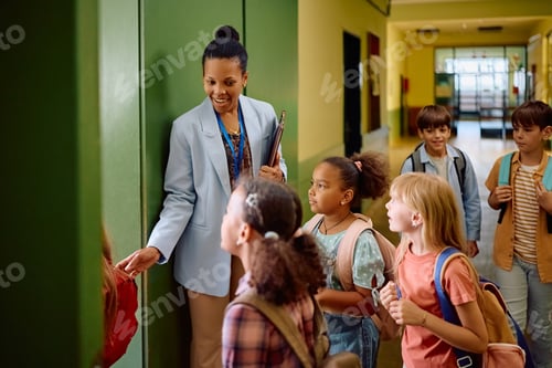 Visualização: Professora negra feliz recebendo seus alunos no primeiro dia de aula.