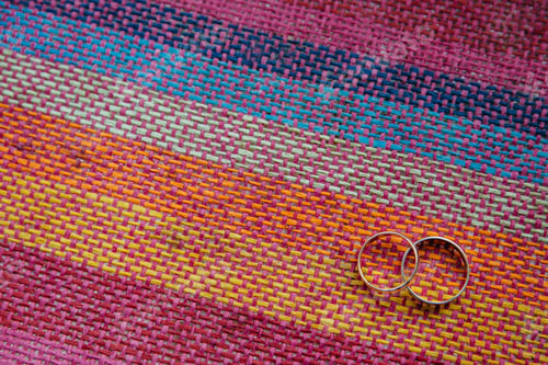 Preview: Golden wedding rings on colourful tissue with blank space for your promotional content