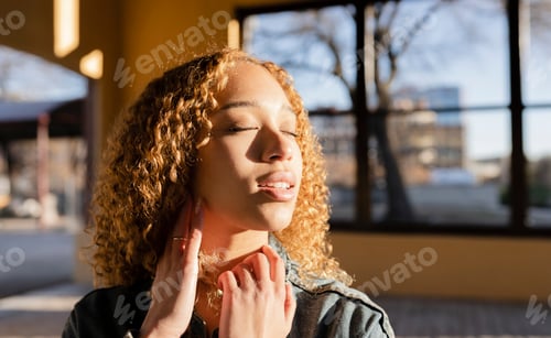 Preview: pretty hispanic woman, curly hair, with eyes closed at sunset, rest, peace, relax