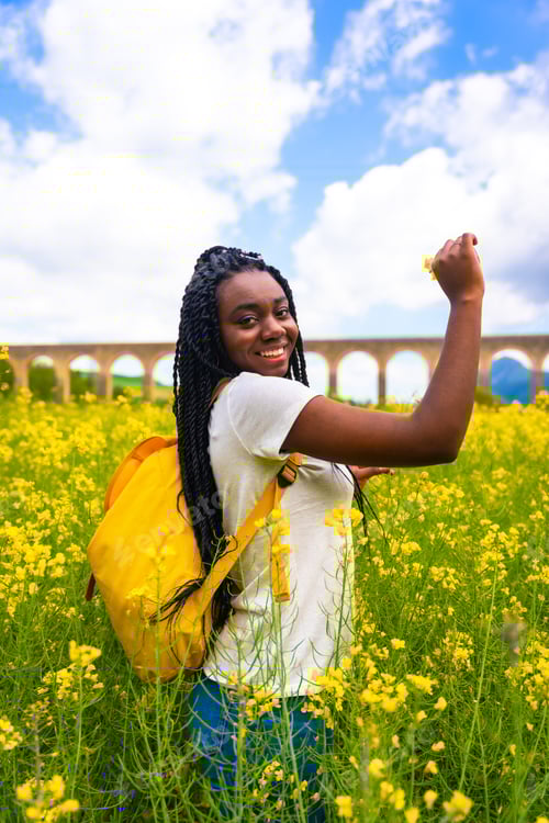 Preview: Breathing fresh air and the scent of the flower, a black ethnic girl with braids