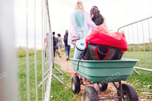 Preview: Close Up Of Trolley As Friends Arrive At Music Festival Carrying Camping Equipment Onto Site