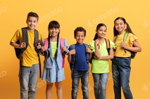 Preview: Multiracial kids posing with backpacks isolated on yellow