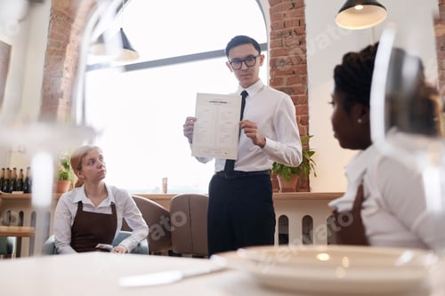 Preview: Restaurant Owner Showing New Menu To Waiting Staff