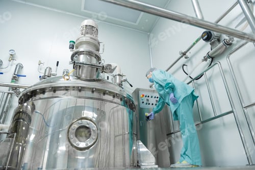 Preview: Pharmaceutical factory woman worker in protective clothing operating production line in sterile