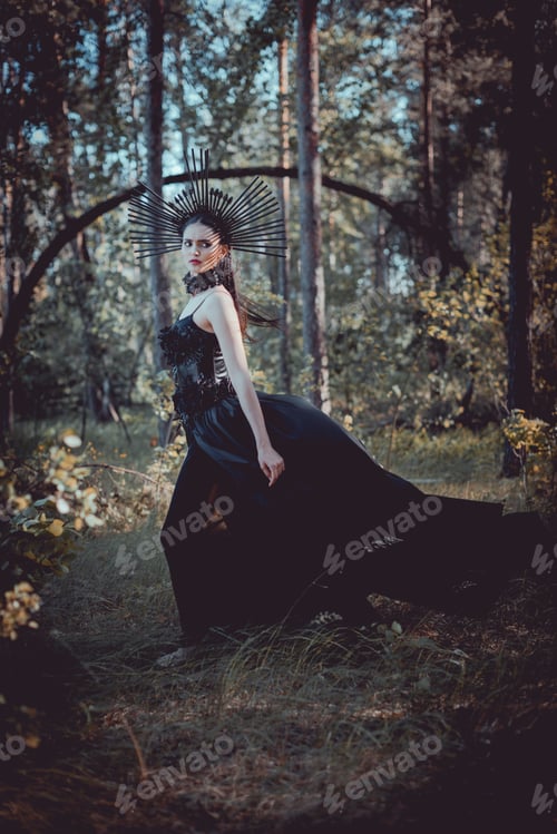 Preview: side view of brunette woman in witch costume standing on forest background, looking away