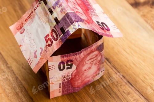 Preview: High angle shot of some South African rand bills on a wooden surface
