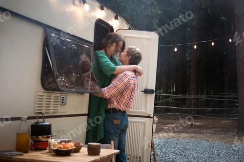 Preview: Happy adult couple living in trailer in forest a summer vacation
