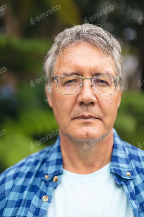 Vorschau: Porträt eines selbstbewussten kaukasischen Senioren mit Brille im Hinterhof am Wochenende