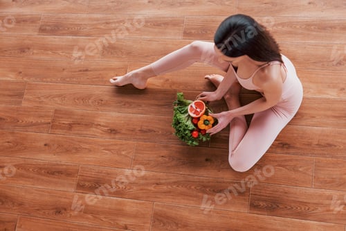 Preview: Top view of sportive woman that sitting on the table with healthy food