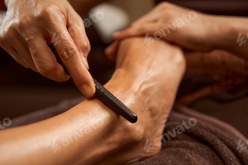 Preview: Practitioner using reflexology stick during Thai foot massage session
