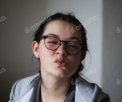 Preview: Young Woman Poses with Pursed Lips Indoors
