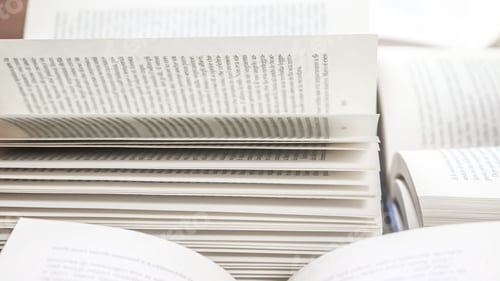 Preview: stack of books, close up. Open book on the table in library.