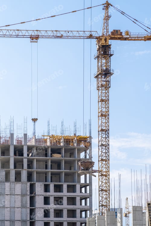 Preview: crane and a building under construction against a blue sky background
