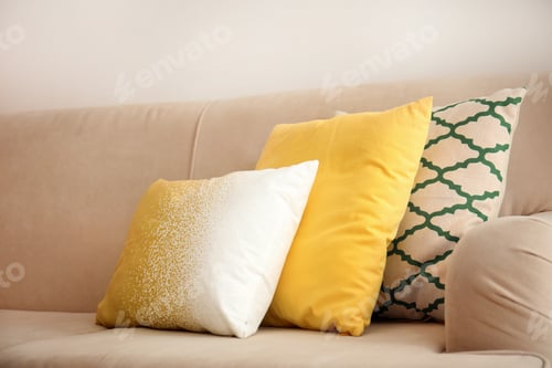Preview: Different soft pillows on sofa in room