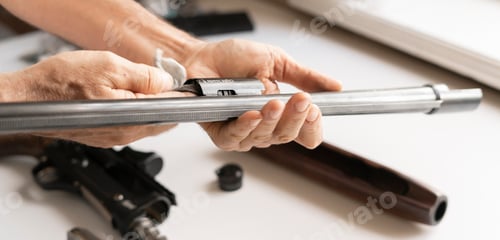 Preview: the man's hands holding rifle parts details and cleaning the gun
