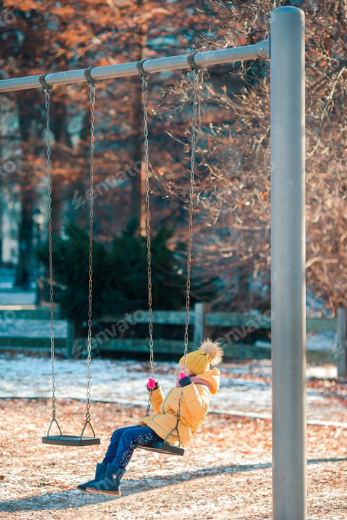 Preview: Adorable little girls swings on a swing in Central Park at New York City