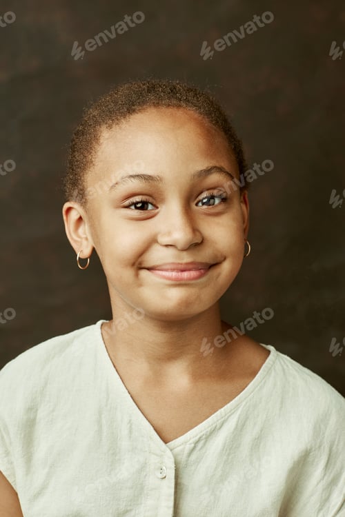 Preview: Cheerful Black Girl Looking at Camera on Brown Background at Studio