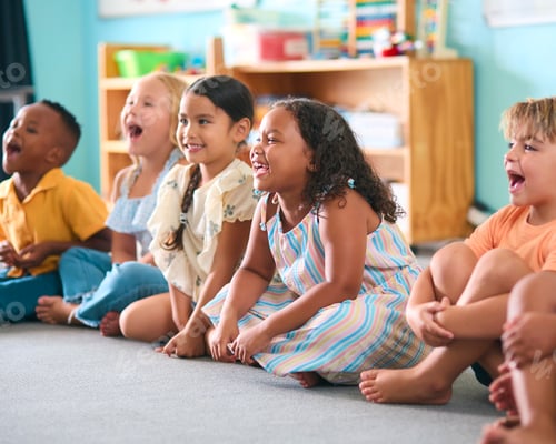 Preview: Line Of Smiling Primary Or Elementary School Students Sitting On Floor During Classroom Lesson