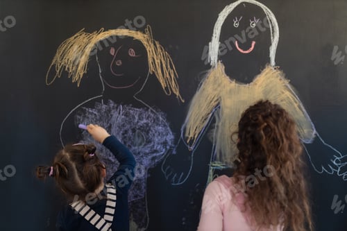 Preview: Rear view of group of little girls drawing with chalks on blackboard wall indoors in playroom