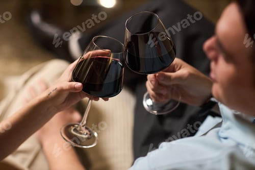 Preview: Young Man and Woman Clinking Wine Glasses Celebrating Together