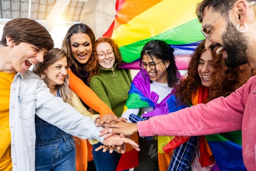 Preview: Homosexual diverse group of young people stacking hands together outdoors