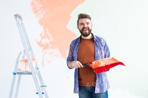 Preview: Repair in the apartment. Man paints the wall with paint