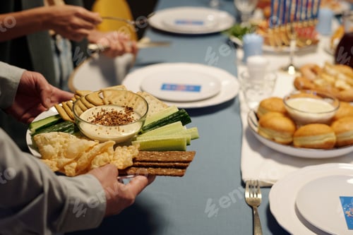 Preview: Focus on plate with fresh cucumber, matzo, pita bread and humus in bowl