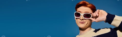 Preview: Young mans playful expression against a vibrant blue sky