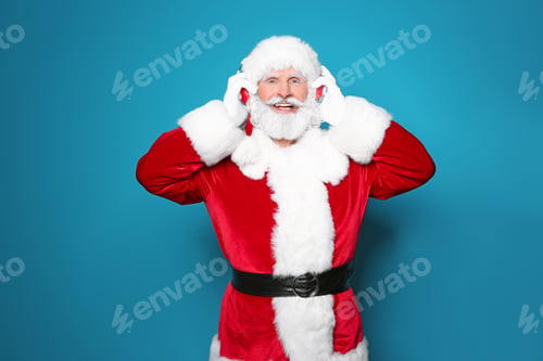 Preview: Santa Claus listening to Christmas music on color background