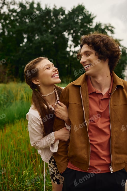 Preview: Young couple enjoys a joyful walk through a lush park, sharing love and laughter