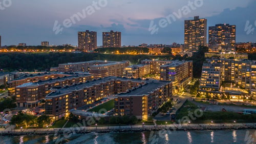 Preview: Cityscape with illuminated buildings and waterfront at dusk