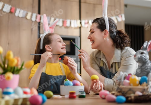 Preview: Joyful Mother and Daughter Painting Easter Eggs in Kitchen